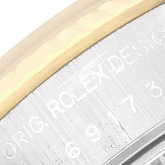 This close-up shows part of the edge and engraved text on the side of the Rolex Datejust 69173 Women's Steel and Gold (two tone) Champagne Dial 69173 Women's Steel and Gold (two tone) Champagne Dial watch case.
