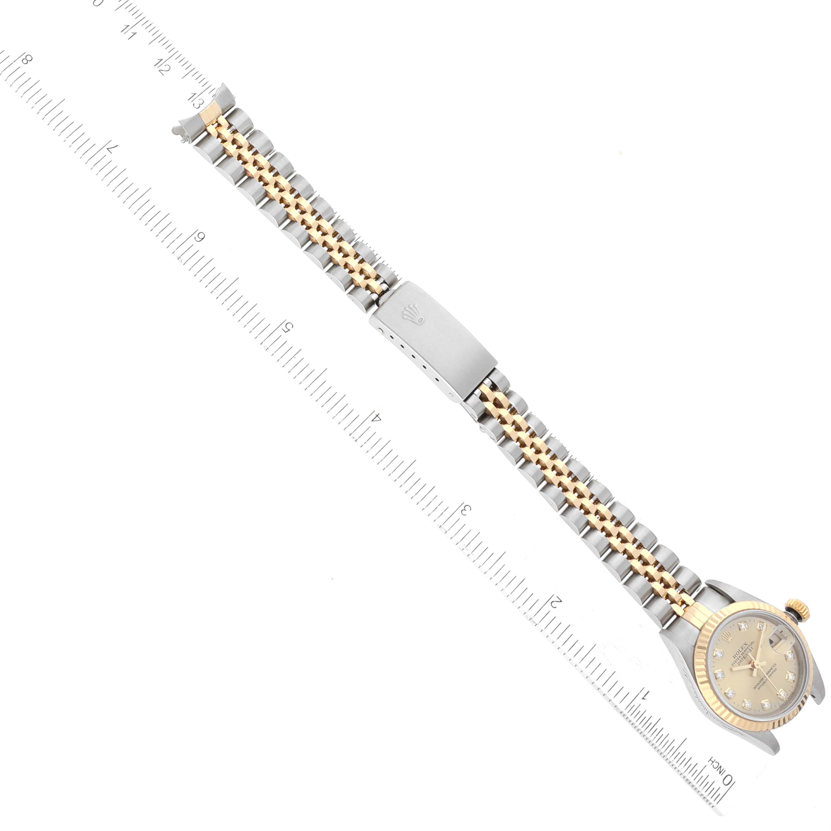 The image shows a top view of a Rolex Datejust 69173 Women's Steel and Gold (two tone) Champagne Dial 69173 Women's Steel and Gold (two tone) Champagne Dial watch and its two-tone bracelet laid out alongside a measuring ruler.