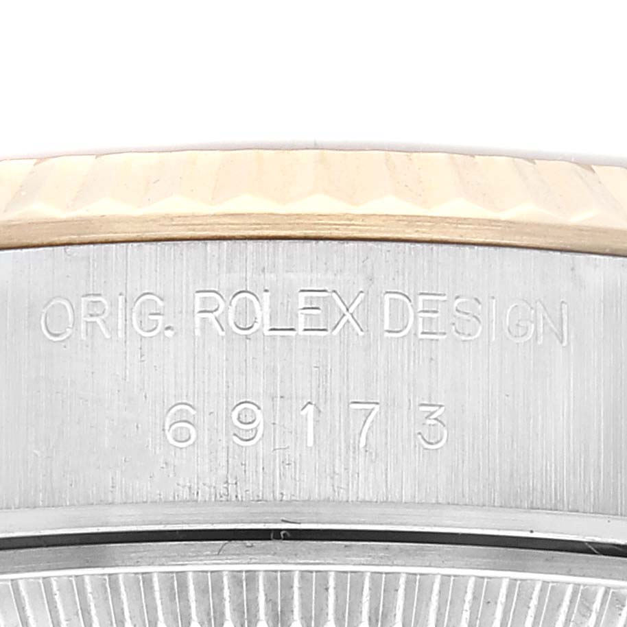 This image shows a close-up of the serial engraving on the side of the bezel and case of a Rolex Datejust 69173 Women's Steel and Gold (two tone) Champagne Dial 69173 Women's Steel and Gold (two tone) Champagne Dial watch.