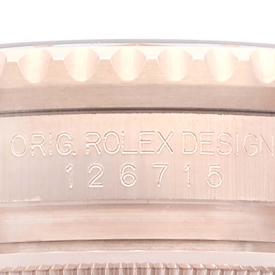 A close-up view of the watch case side of the Rolex GMT-Master 126715 Men
s Rose Gold Black Dial 126715 Men
s Rose Gold Black Dial model reveals part of its fluted bezel and the engraved model number 126715.