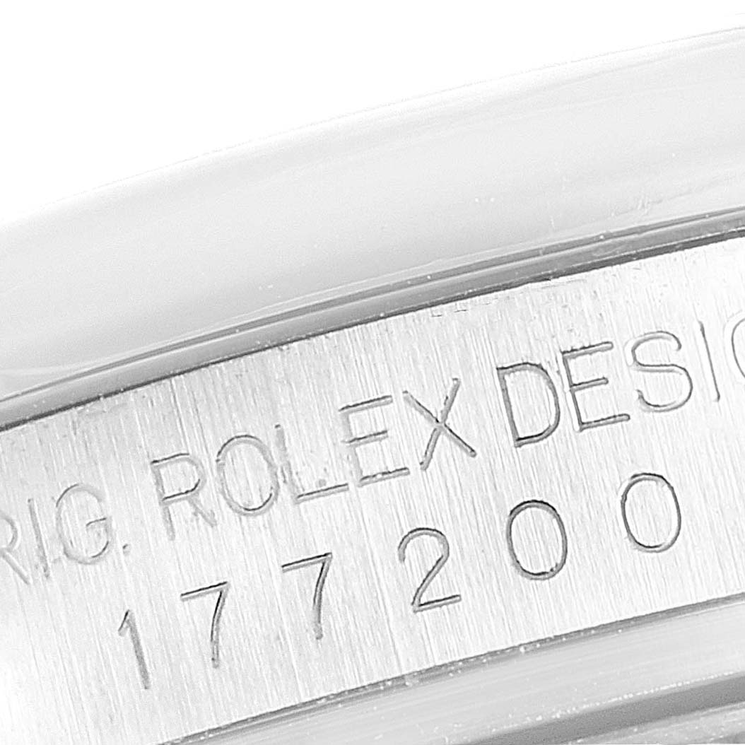 The image shows a close-up of the engraved serial number and text on the case of a Mid-Size Rolex watch.