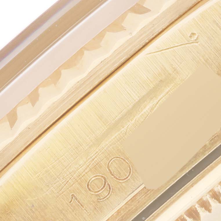 This close-up image shows a partial view of the case and bezel of a Rolex Vintage Collection 1803 Men's Yellow Gold Champagne Dial 1803 Men's Yellow Gold Champagne Dial model, with visible engraving.