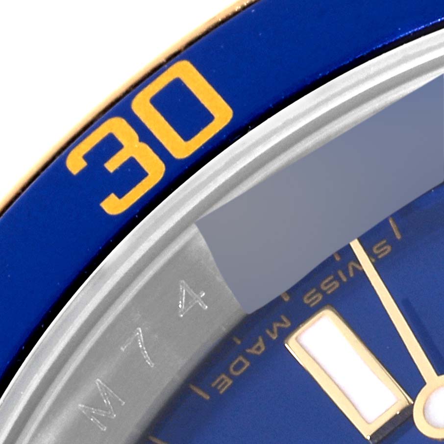 This close-up image of the Rolex Submariner 16613 Men
s Stainless Steel Blue Dial 16613 Men
s Stainless Steel Blue Dial shows part of the blue bezel with the yellow "30" marking and part of the watch dial.