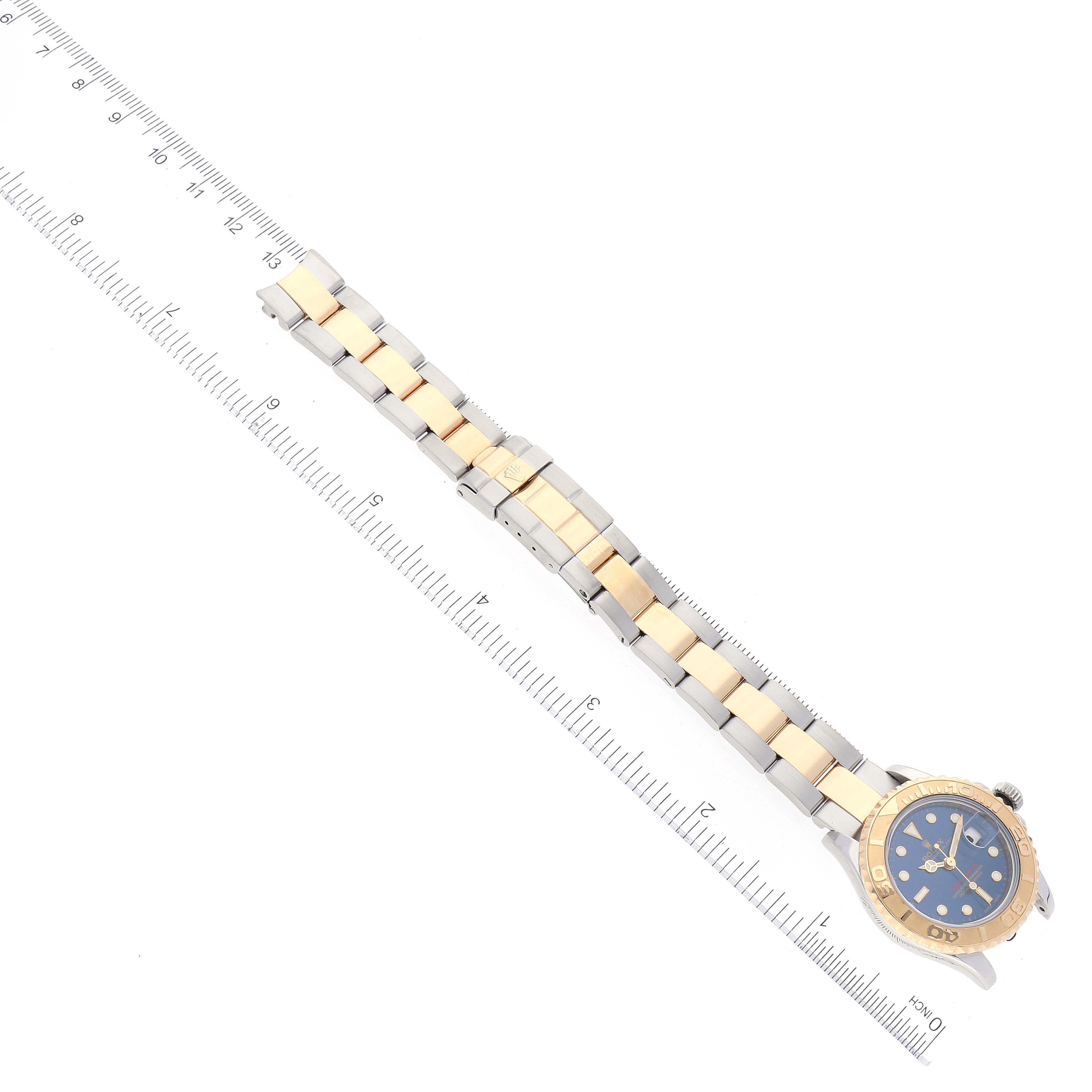 The image shows a Rolex Yacht-Master 169623 Women's Steel and Gold (two tone) Blue Dial 169623 Women's Steel and Gold (two tone) Blue Dial watch at an angled top view, including the face, bezel, and metal bracelet with a ruler for scale.