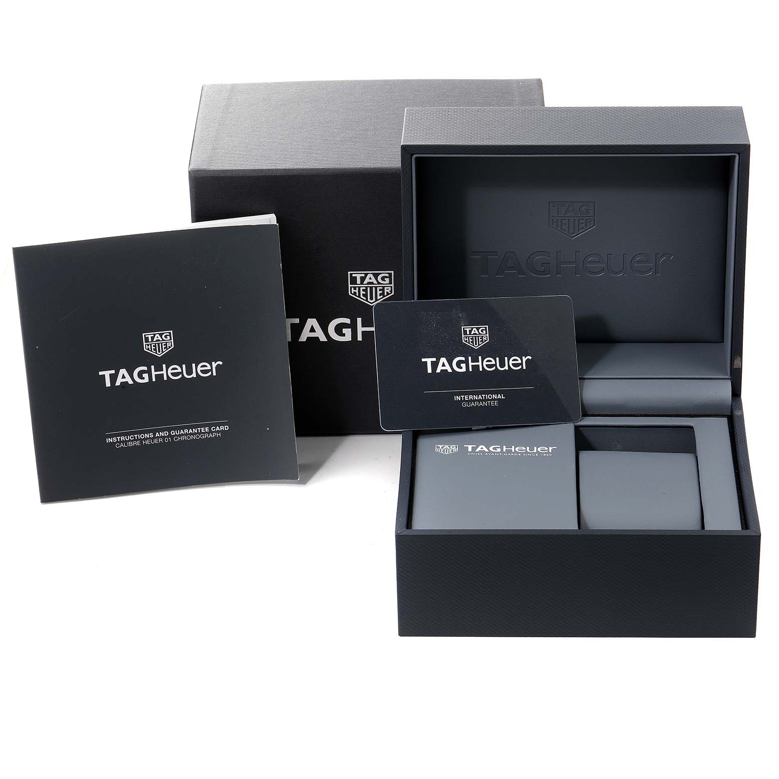 The image shows the packaging, guarantee card, and instruction manual for the Tag Heuer Carrera CAR2A1W.BA0703 Men's Stainless Steel Transparent Dial CAR2A1W.BA0703 Men's Stainless Steel Transparent Dial model watch.