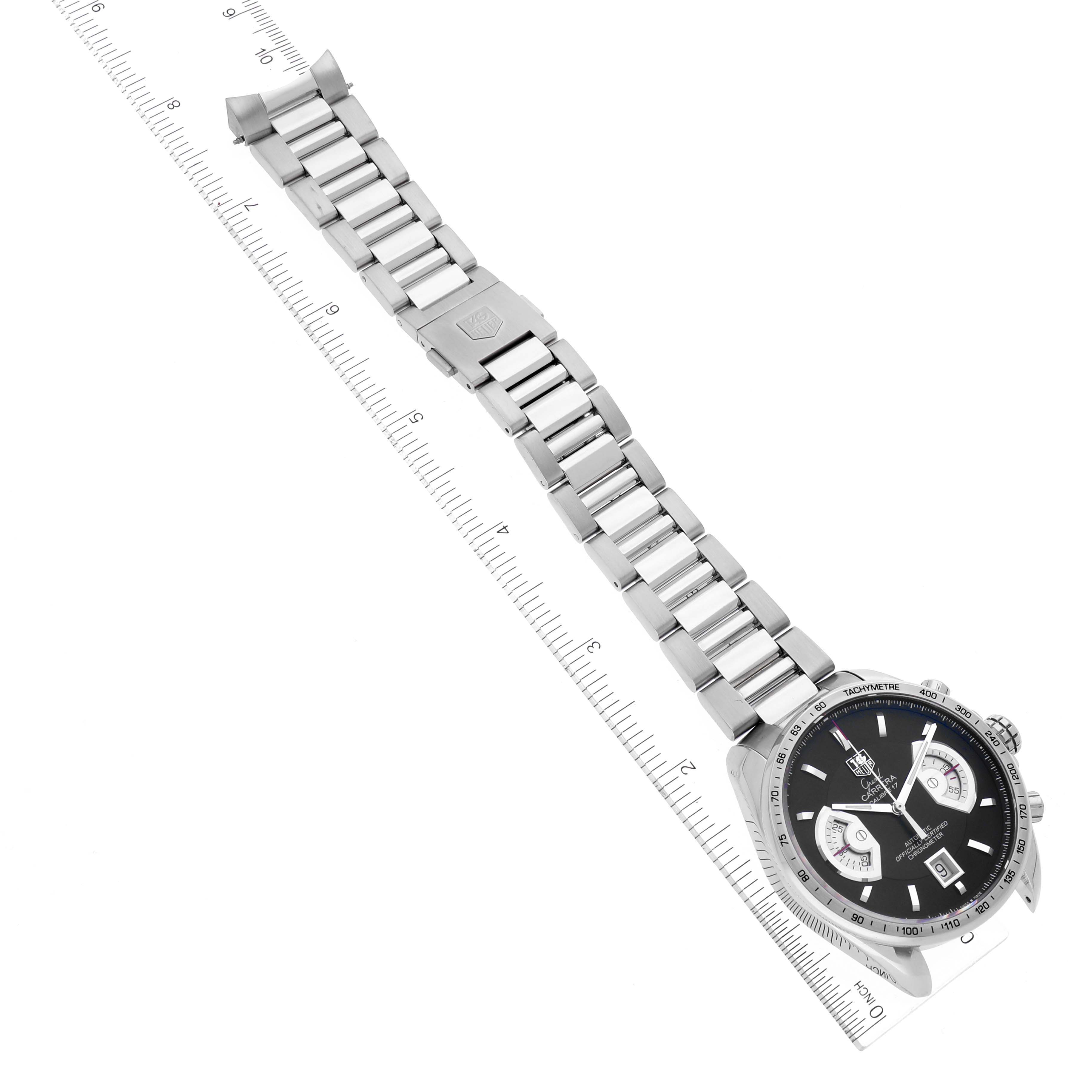 The image shows a top-down view of the Tag Heuer Carrera CAV511G Men's Stainless Steel Black Dial CAV511G Men's Stainless Steel Black Dial watch, including its face, bracelet, and clasp, next to a ruler for scale.