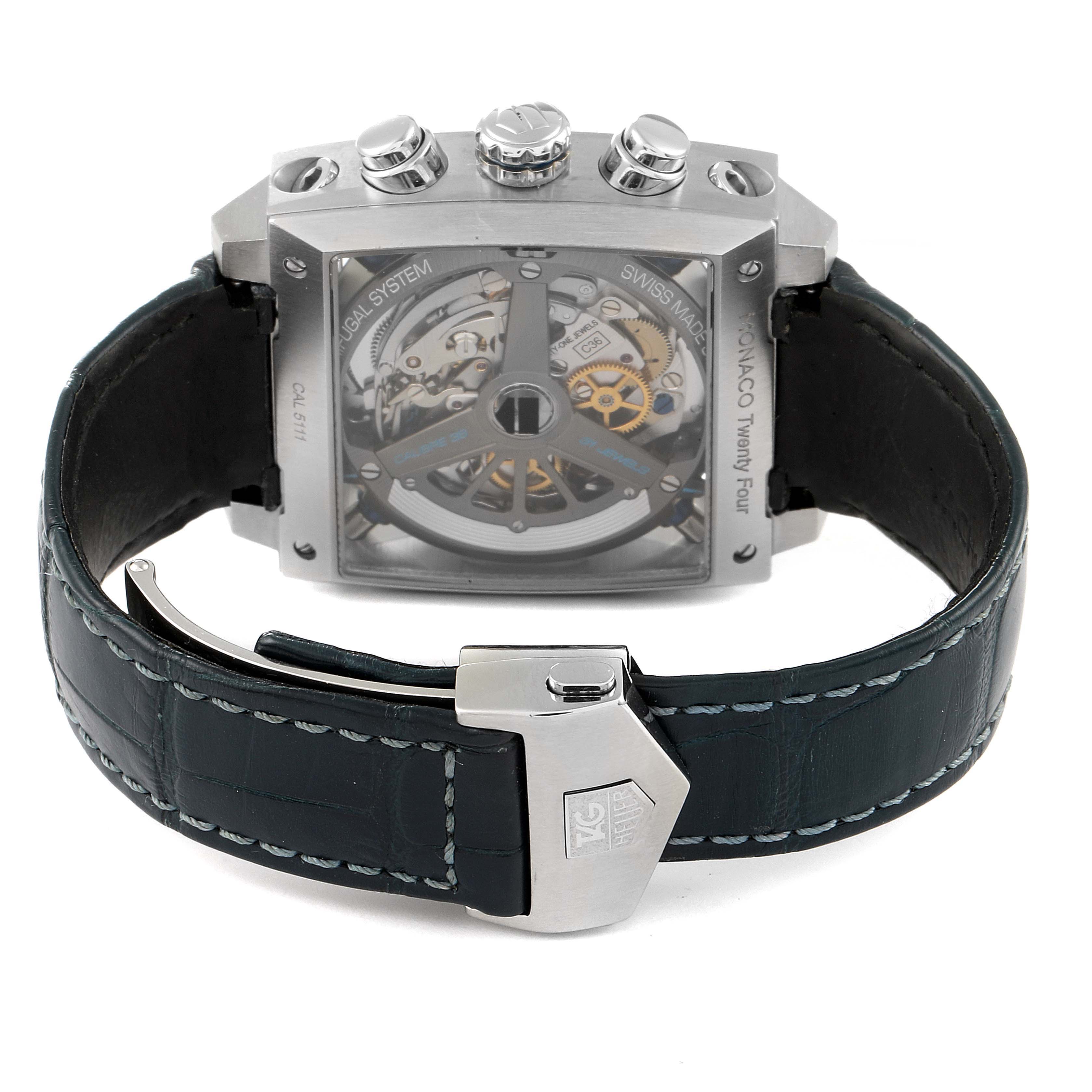 The image shows the back view of a Tag Heuer Monaco CAL5111.FC6299 Men
s Stainless Steel Blue Dial CAL5111.FC6299 Men
s Stainless Steel Blue Dial watch, revealing its movement and a leather strap with a clasp.