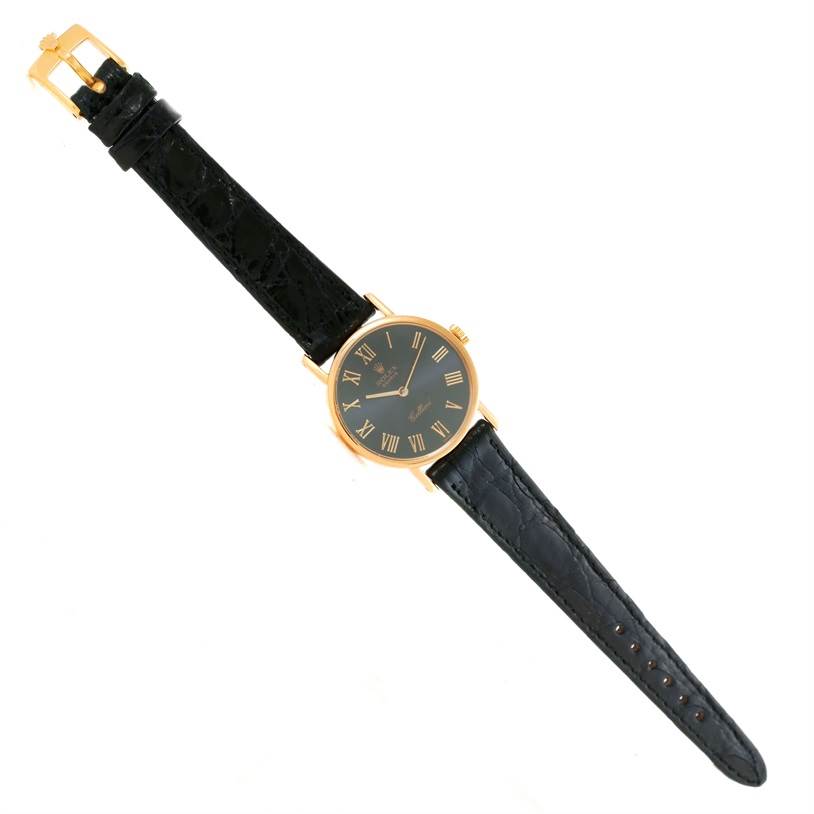 The image shows a Rolex Cellini 5109 Women's Yellow Gold Grey Dial 5109 Women's Yellow Gold Grey Dial watch from a top-down angle, highlighting the black leather strap and gold-tone case with Roman numeral markers.