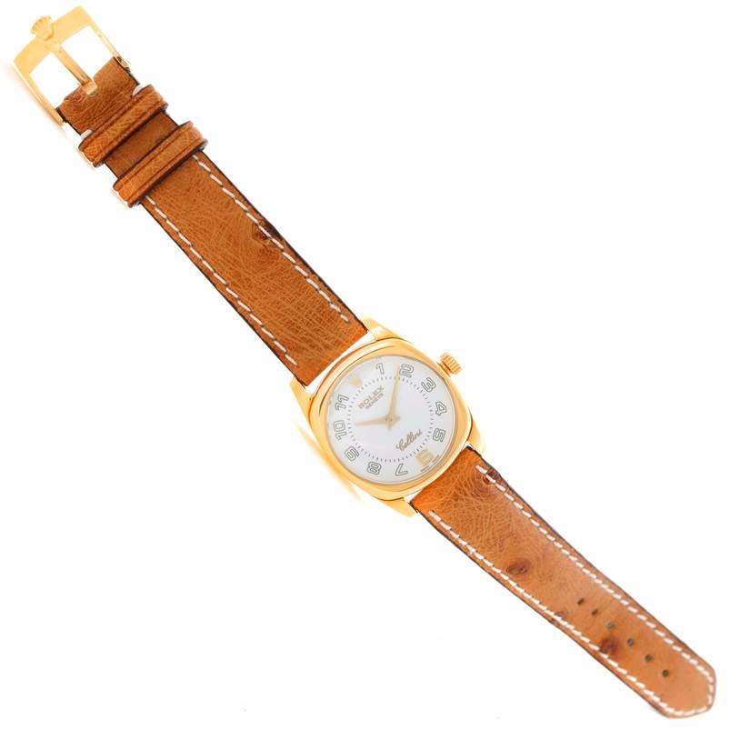 The Rolex Cellini 6229 Women's Yellow Gold White Dial 6229 Women's Yellow Gold White Dial watch is shown from a top-down angle, highlighting its brown leather strap and round gold case with a white dial.