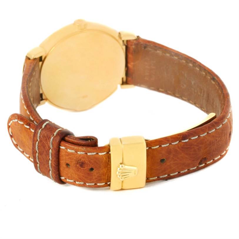 The image shows the back angle of a Rolex Cellini 6621 Women's Yellow Gold Champagne Dial 6621 Women's Yellow Gold Champagne Dial watch, highlighting its leather strap and gold buckle with the Rolex logo.