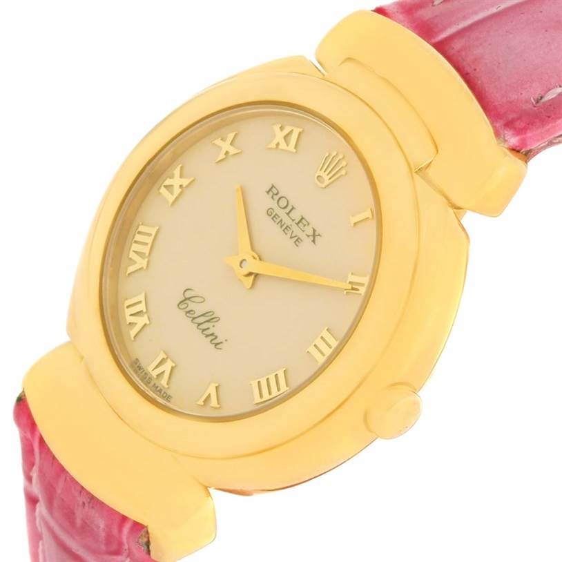 The Rolex Cellini 6621 Women's Yellow Gold Beige Dial 6621 Women's Yellow Gold Beige Dial watch is shown at an angled view, highlighting the face, bezel, crown, and part of the pink leather strap.