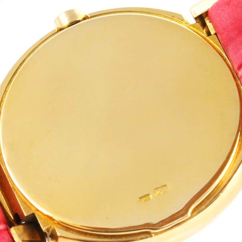 This image shows the back case of a Rolex Cellini 6621 Women's Yellow Gold Beige Dial 6621 Women's Yellow Gold Beige Dial watch at a slight angle with part of a red strap visible.