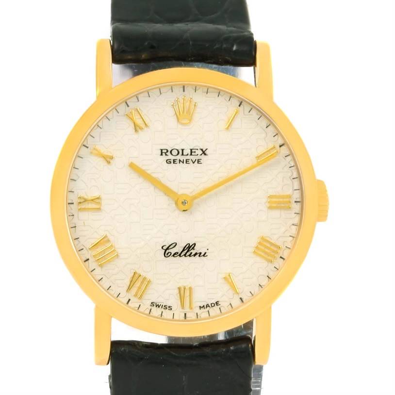 The image shows a frontal view of a Rolex Cellini watch with a gold case and black strap.