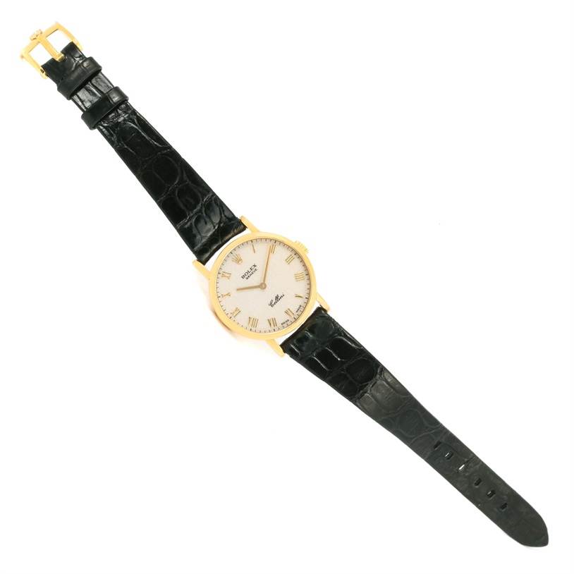 The Rolex Cellini 5109 Women's Yellow Gold Beige Dial 5109 Women's Yellow Gold Beige Dial watch is pictured from a top-down angle, showcasing its face, black leather strap, and gold casing.