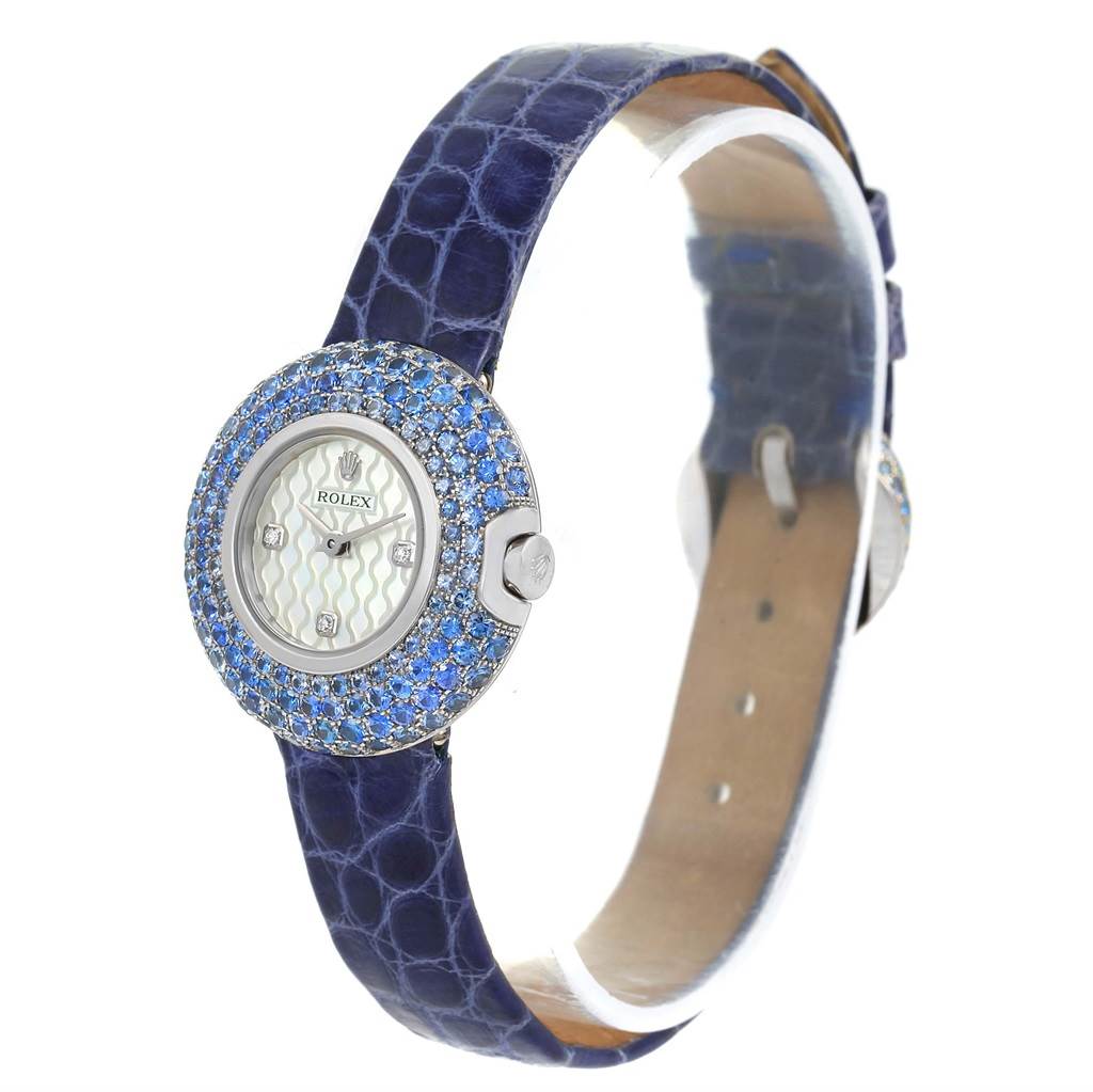 The image shows a Rolex Cellini 6201 Women's White Gold Mother of Pearl Dial 6201 Women's White Gold Mother of Pearl Dial watch at an angled side view, highlighting its jeweled bezel and textured blue strap.