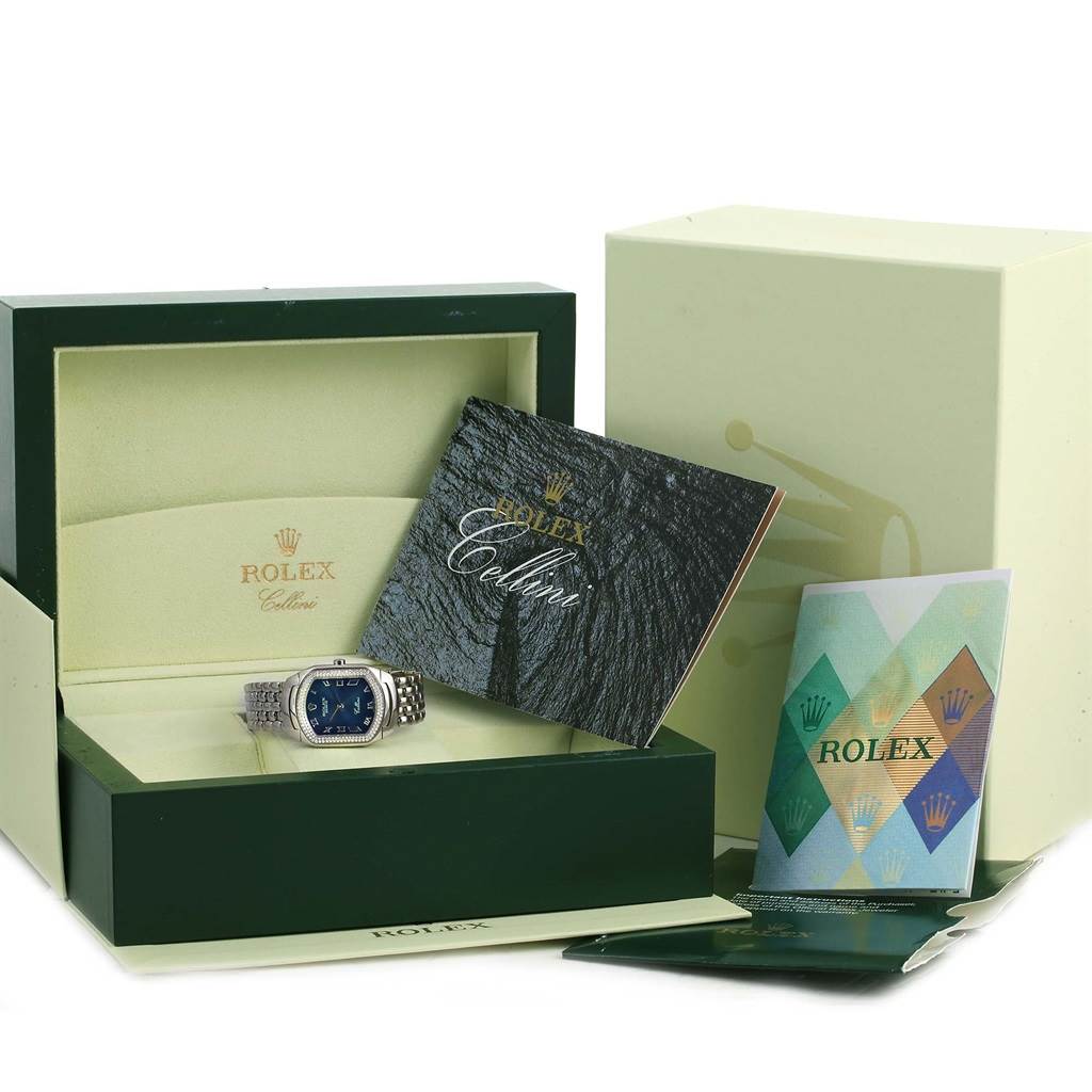 The image shows a Rolex Cellini 6691 Women
s White Gold Blue Dial 6691 Women
s White Gold Blue Dial watch in its open box, surrounded by manuals and a warranty booklet.