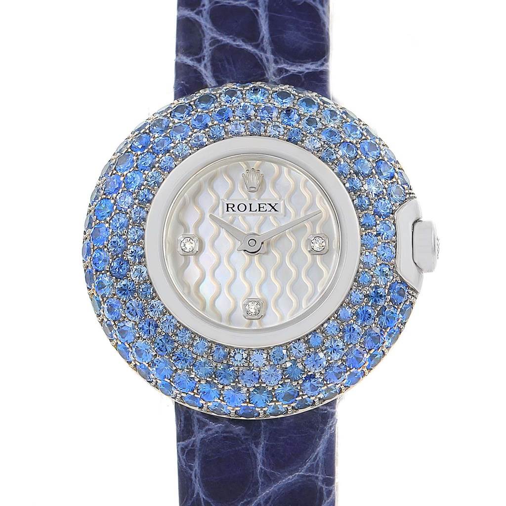 This image shows a front view of a Rolex Cellini 6201 Women's White Gold Mother of Pearl Dial 6201 Women's White Gold Mother of Pearl Dial model watch with a blue gem-encrusted bezel and a blue strap.