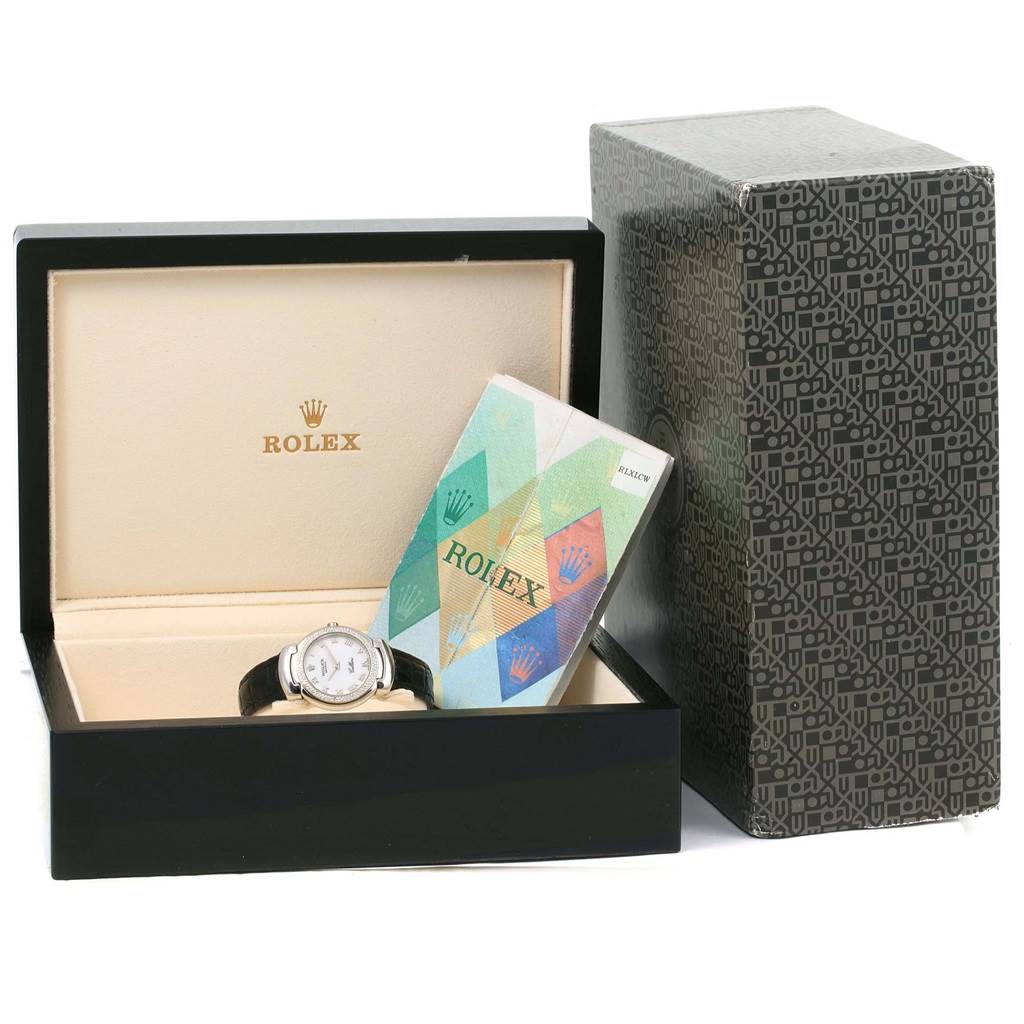 The image shows a Rolex Cellini 6671 Women's White Gold White Dial 6671 Women's White Gold White Dial watch from a front angle, placed in an open box with documentation beside it.