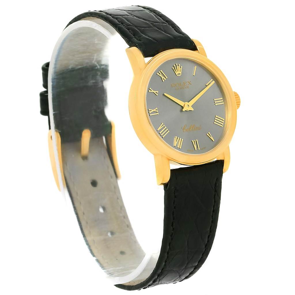 The Rolex Cellini 6110 Women's Yellow Gold Grey Dial 6110 Women's Yellow Gold Grey Dial watch is shown at a side angle, highlighting its gold case, black leather strap, and Roman numeral dial.