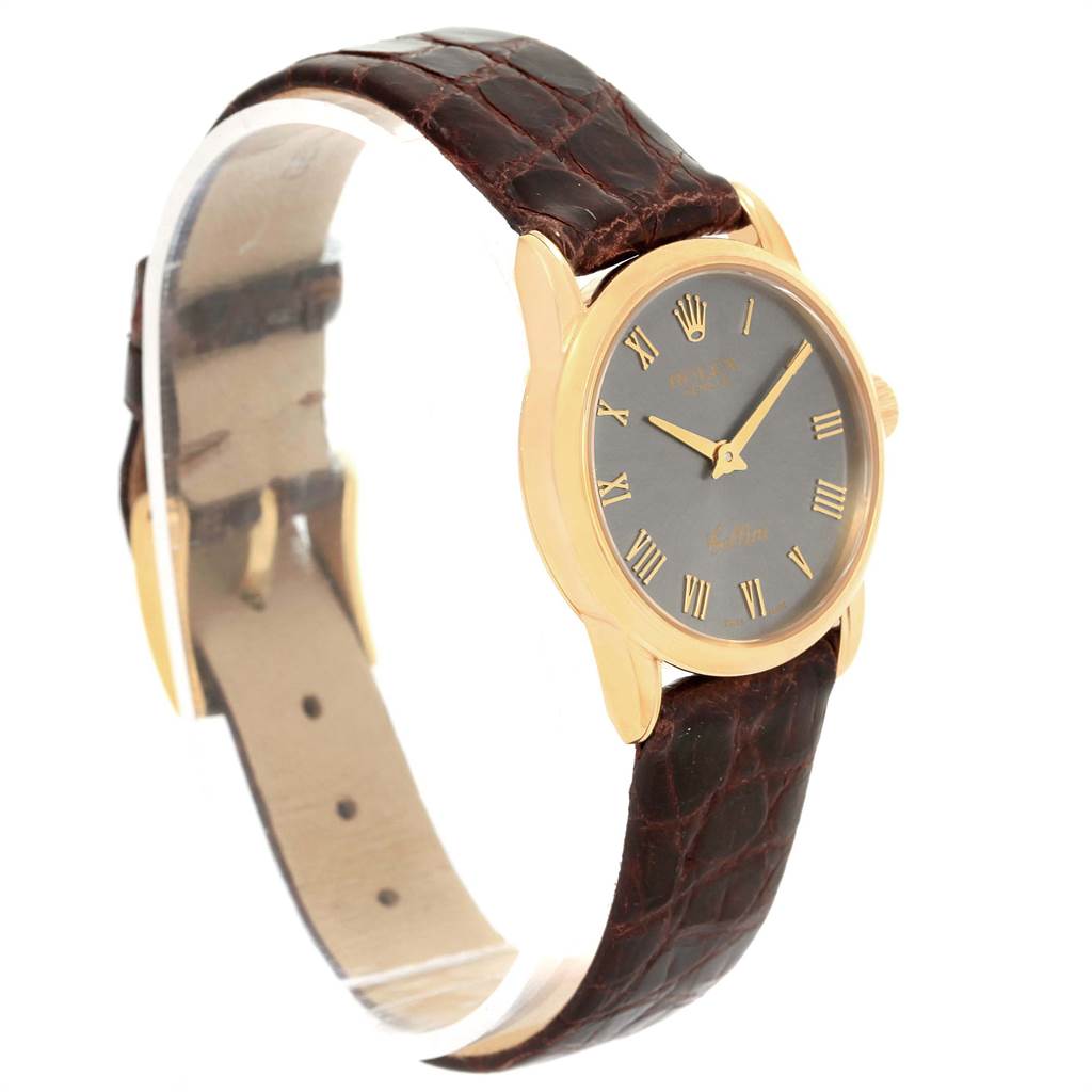 The Rolex Cellini 6111 Women's Yellow Gold Grey Dial 6111 Women's Yellow Gold Grey Dial watch is shown at an angle highlighting the face, gold bezel, and brown crocodile leather strap.