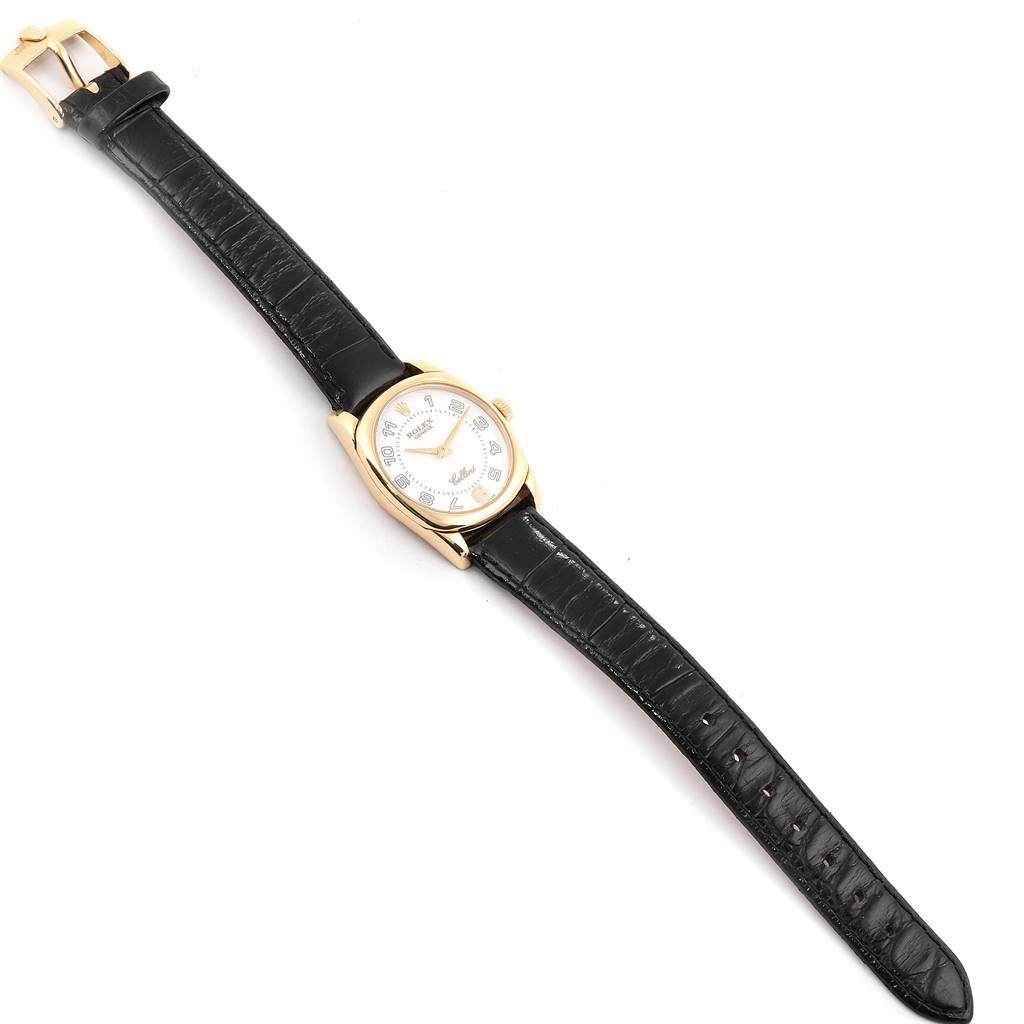 The image shows a Rolex Cellini 6229 Women
s Yellow Gold White Dial 6229 Women
s Yellow Gold White Dial watch at a top-down angle, featuring its face, leather strap, and buckle.