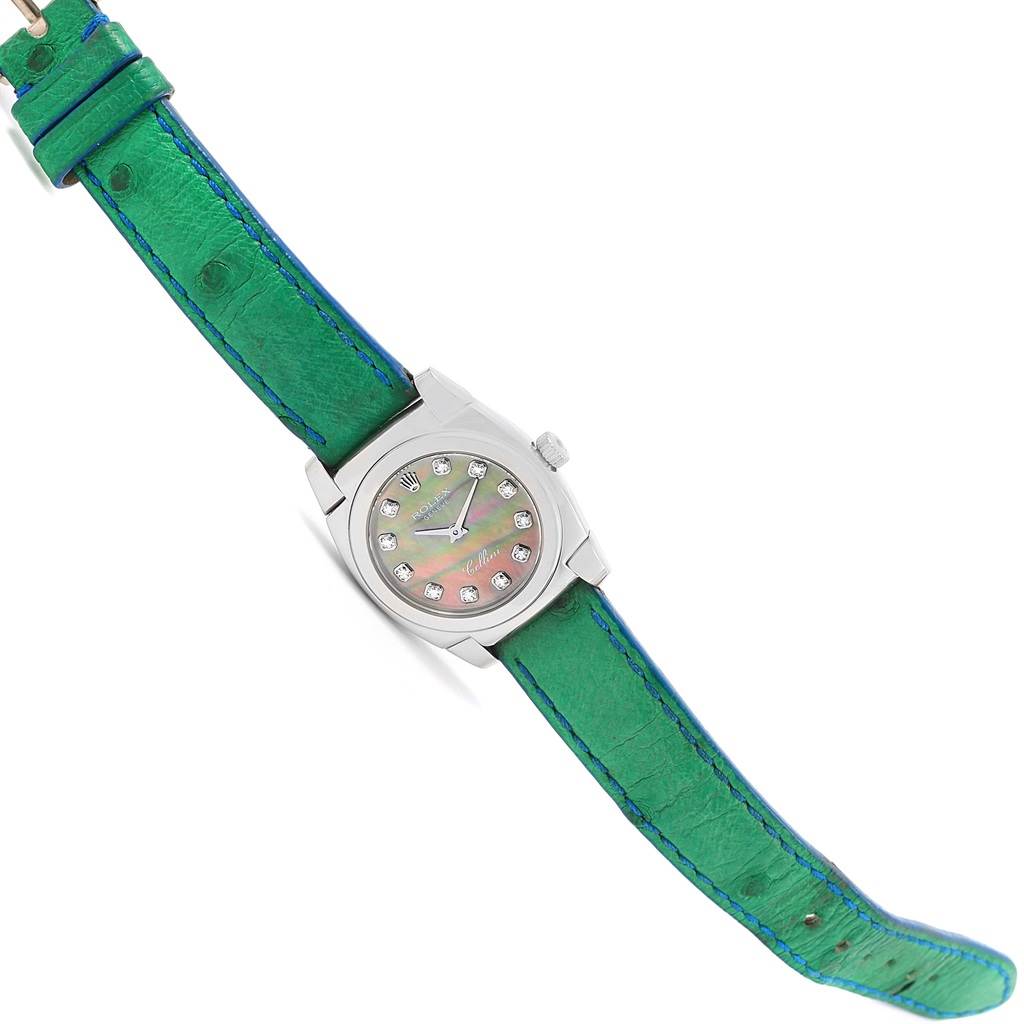 The image shows a Rolex Cellini 5310 Women's White Gold Mother of Pearl Dial 5310 Women's White Gold Mother of Pearl Dial watch from a top-down angle, featuring a green strap and a dial with gem markers.