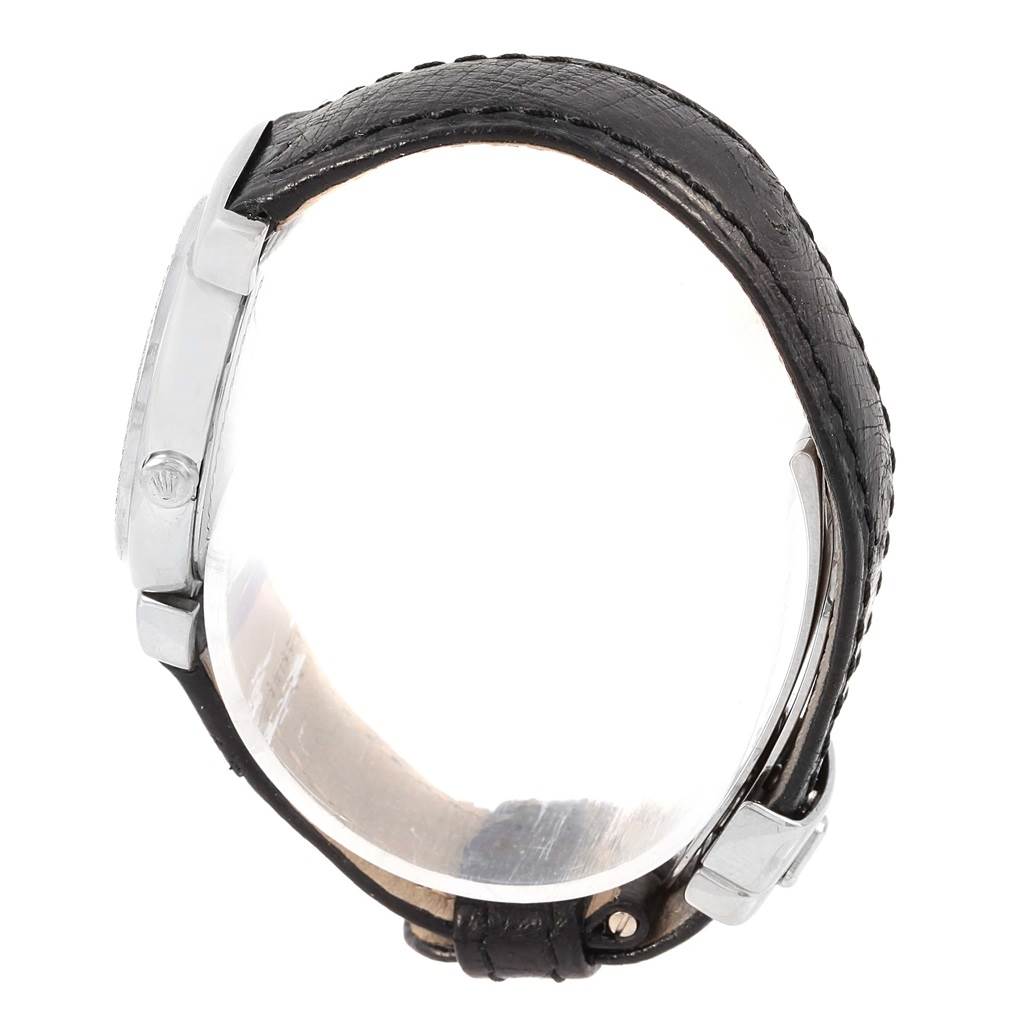 The Rolex Cellini 6671 Women
s White Gold Silver Dial 6671 Women
s White Gold Silver Dial watch is shown from a side angle, displaying its case, crown, lugs, and black leather strap.