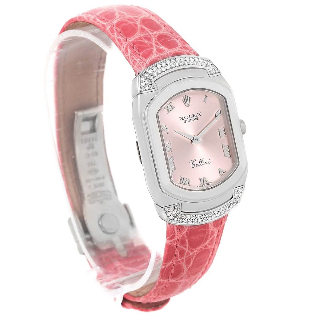 This Rolex Cellini 6692 Women
s White Gold Pink Dial 6692 Women
s White Gold Pink Dial watch is shown from a diagonal angle, highlighting its pink dial, silver case with diamonds, and pink strap.