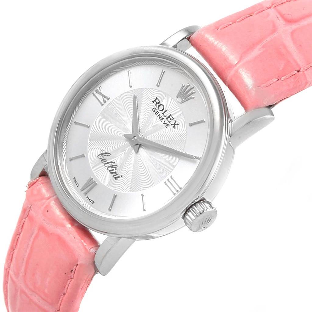 The angle shows the watch face, crown, and part of the pink strap of the Rolex Cellini 6110 Women
s White Gold Silver Dial 6110 Women
s White Gold Silver Dial model.