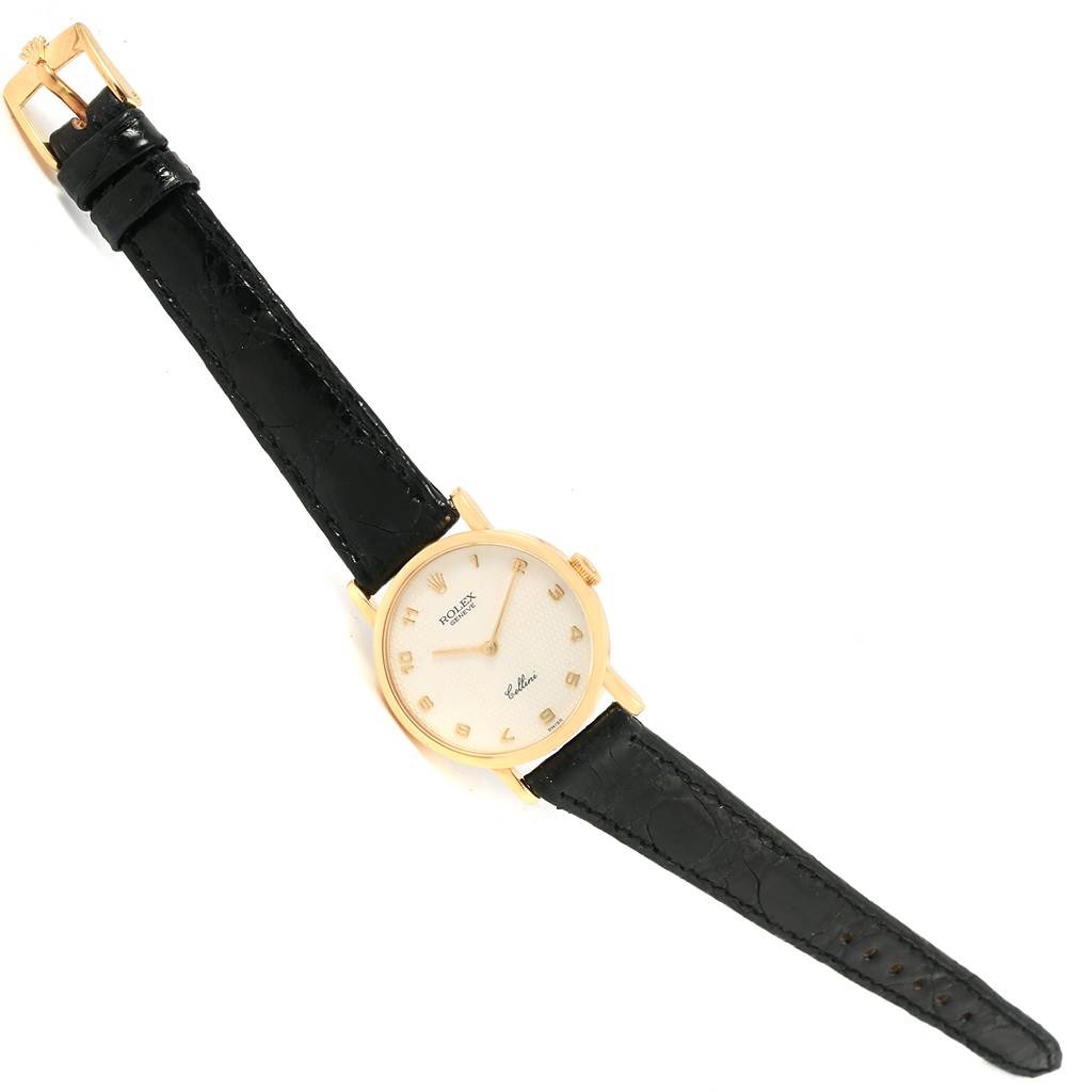 The Rolex Cellini 5109 Women's Yellow Gold Mother of Pearl Dial 5109 Women's Yellow Gold Mother of Pearl Dial watch is shown from a top-down angle, featuring the dial, black leather strap, and gold case.