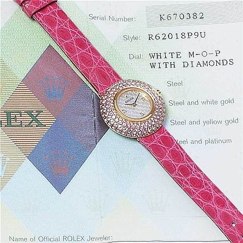The image shows a Rolex Cellini 6201 Women's Yellow Gold Mother of Pearl Dial 6201 Women's Yellow Gold Mother of Pearl Dial watch with a pink strap and diamond-encrusted face, viewed from above, alongside its authentication card.