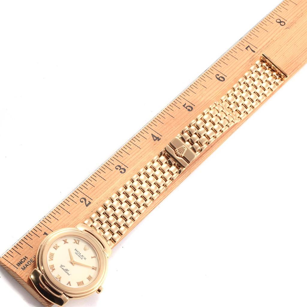 The image shows a Rolex Cellini 6622 Women's Yellow Gold White Dial 6622 Women's Yellow Gold White Dial watch laid flat next to a ruler, highlighting its face, bezel, and bracelet.
