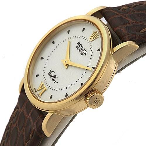 This image shows a side angle of a Rolex Cellini 6110 Women's Yellow Gold Silver Dial 6110 Women's Yellow Gold Silver Dial watch, displaying its crown, bezel, dial, and part of the leather strap.