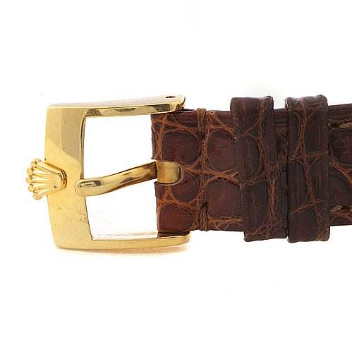 The image shows a close-up of a Rolex Cellini 6110 Women's Yellow Gold Silver Dial 6110 Women's Yellow Gold Silver Dial watch buckle and part of the brown leather strap.