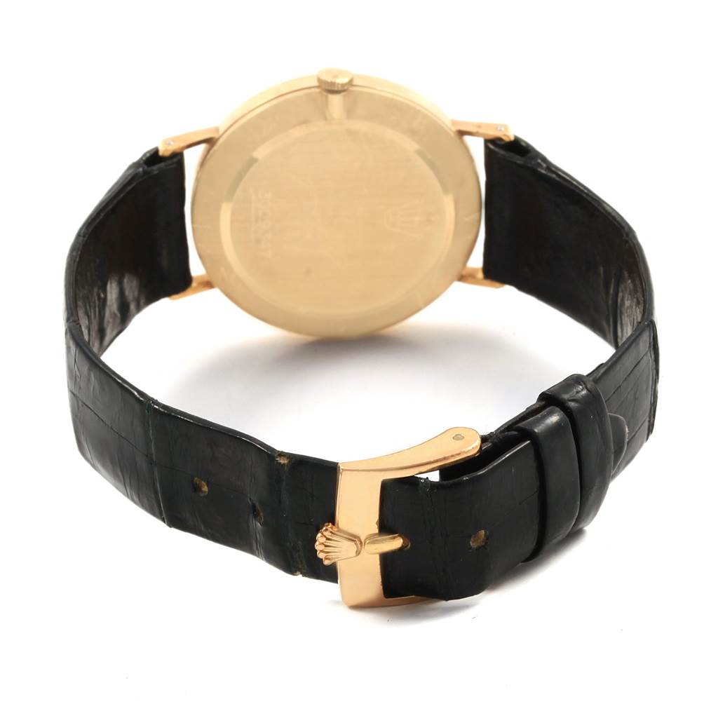 The image shows the back of a Rolex Cellini 3833 Men's Yellow Gold White Dial 3833 Men's Yellow Gold White Dial watch with its gold case and black leather strap, highlighting the buckle.