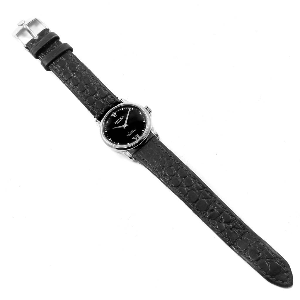 The image shows a top-down view of a Rolex Cellini 6111 Women's White Gold Black Dial 6111 Women's White Gold Black Dial watch, displaying its black dial, casing, and black leather strap with buckle.