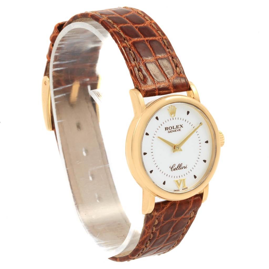 The Rolex Cellini 6110 Women's Yellow Gold Silver Dial 6110 Women's Yellow Gold Silver Dial watch is shown at a three-quarter angle, displaying its brown leather strap and gold case with a white dial.
