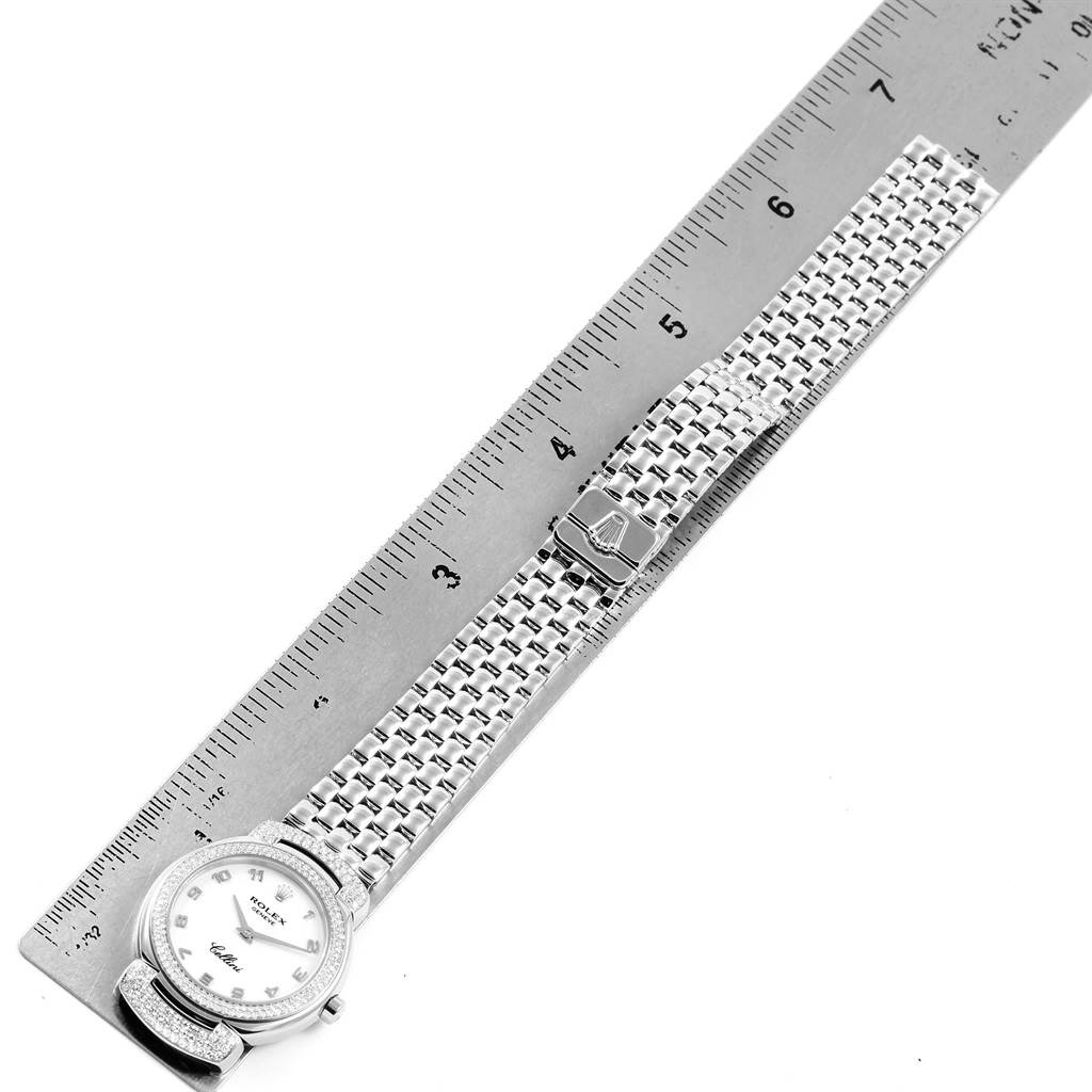 The Rolex Cellini 6673 Women's White Gold White Dial 6673 Women's White Gold White Dial watch is shown from a top-down angle, displaying its full length, dial, bracelet, and clasp, alongside a ruler for scale.
