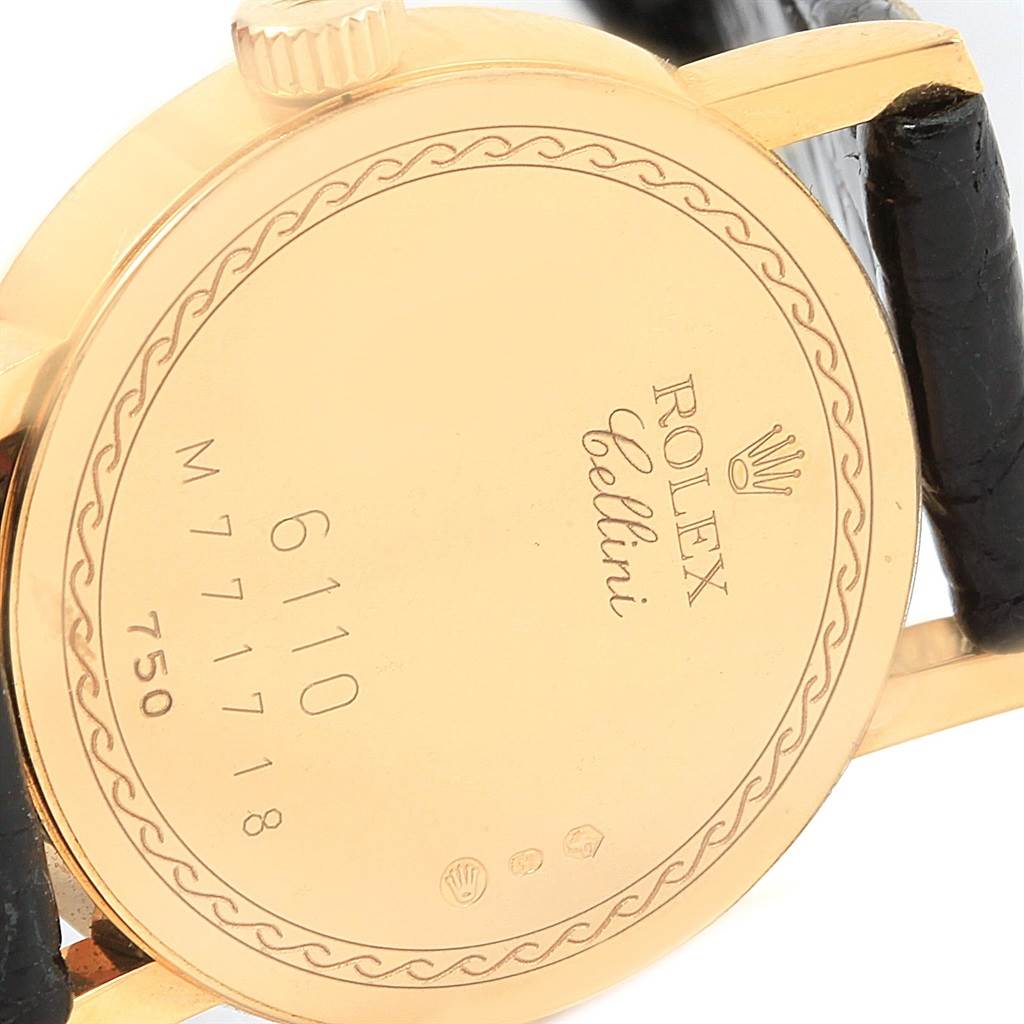 The image shows the back case and part of the strap of the Rolex Cellini 6110 Women
s Yellow Gold Grey Dial 6110 Women
s Yellow Gold Grey Dial watch, showcasing the model number and branding.