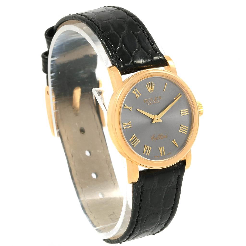 The image shows a side angle of the Rolex Cellini 6110 Women
s Yellow Gold Grey Dial 6110 Women
s Yellow Gold Grey Dial watch, highlighting the dial, gold case, and black leather strap.