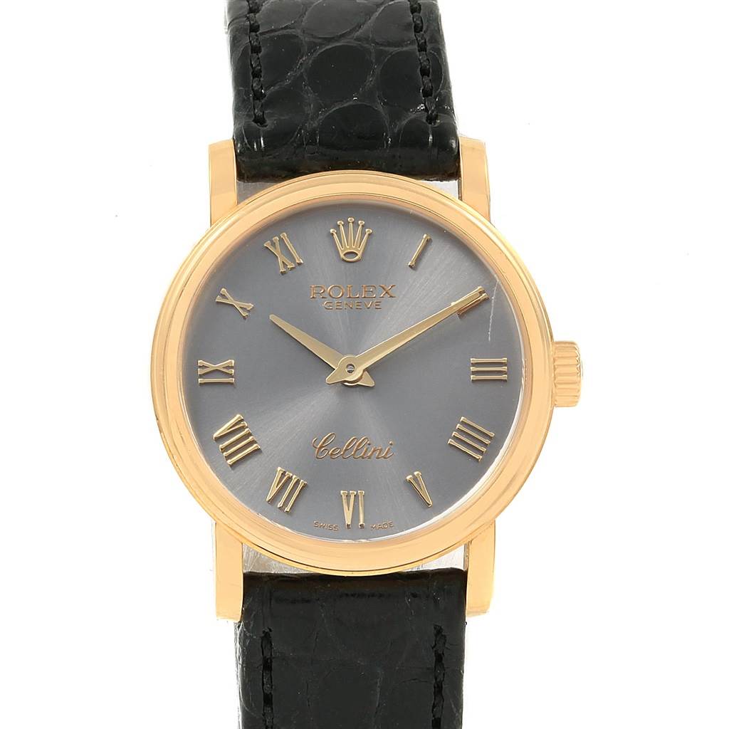 The image shows a Rolex Cellini 6110 Women
s Yellow Gold Grey Dial 6110 Women
s Yellow Gold Grey Dial watch from a front angle, displaying its face, hands, and part of the strap.