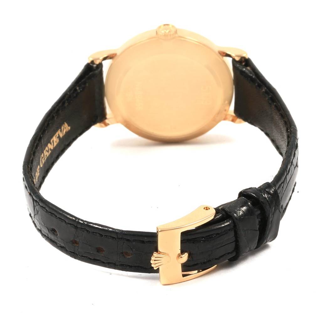 This is a rear angle view of a Rolex Cellini 5109 Women's Yellow Gold Champagne Dial 5109 Women's Yellow Gold Champagne Dial watch showing the back case and black leather strap with a gold buckle.