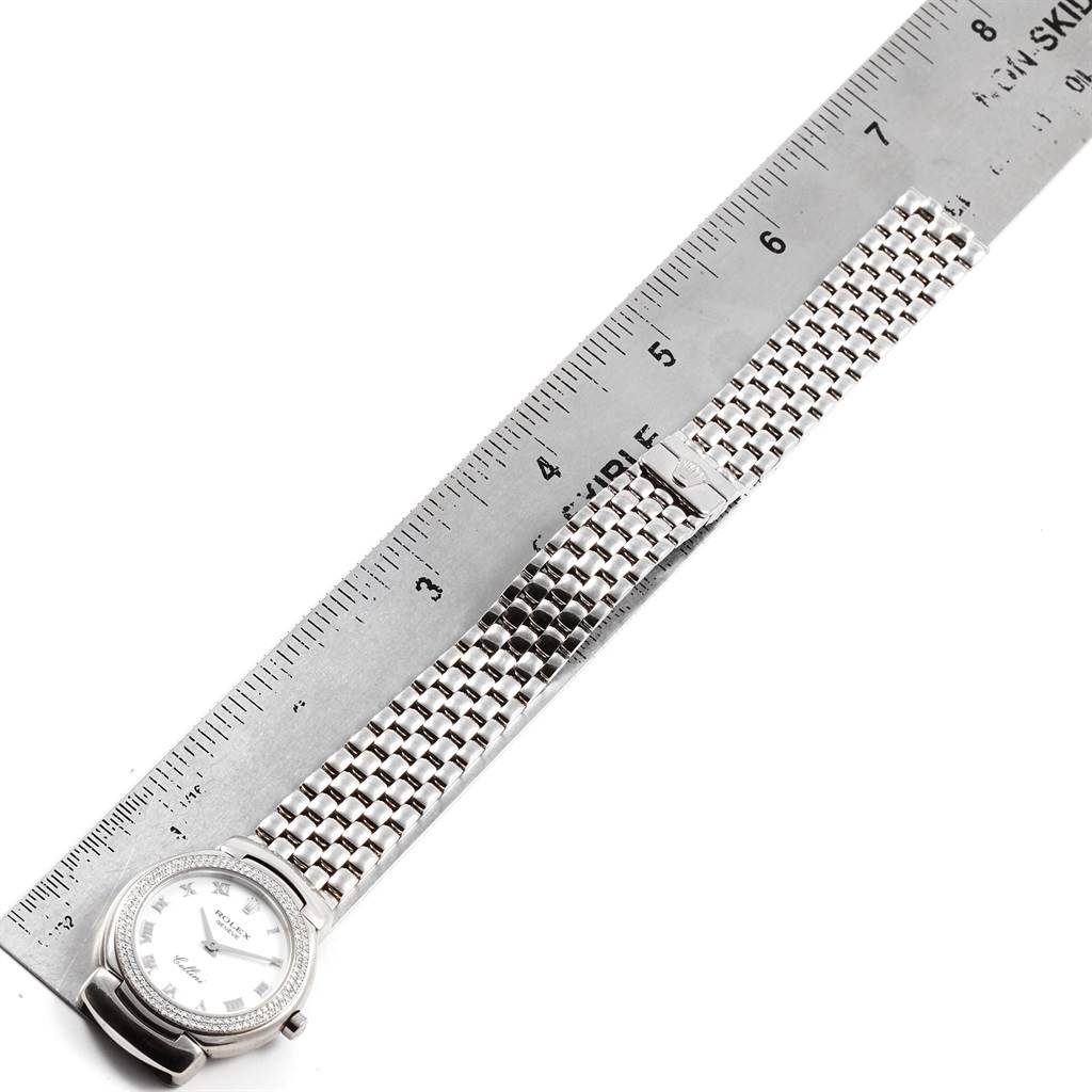 The Rolex Cellini 6671 Women's White Gold White Dial 6671 Women's White Gold White Dial watch is shown from a top-down angle, displaying the watch face and metal bracelet alongside a ruler for scale.
