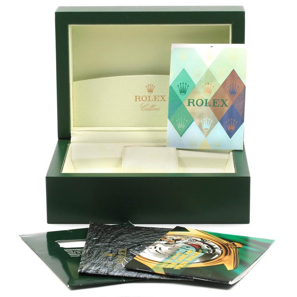 This image shows an open green Rolex Cellini 6691 Women
s White Gold Mother of Pearl Dial 6691 Women
s White Gold Mother of Pearl Dial watch box, with pamphlets and booklets arranged in front of it.