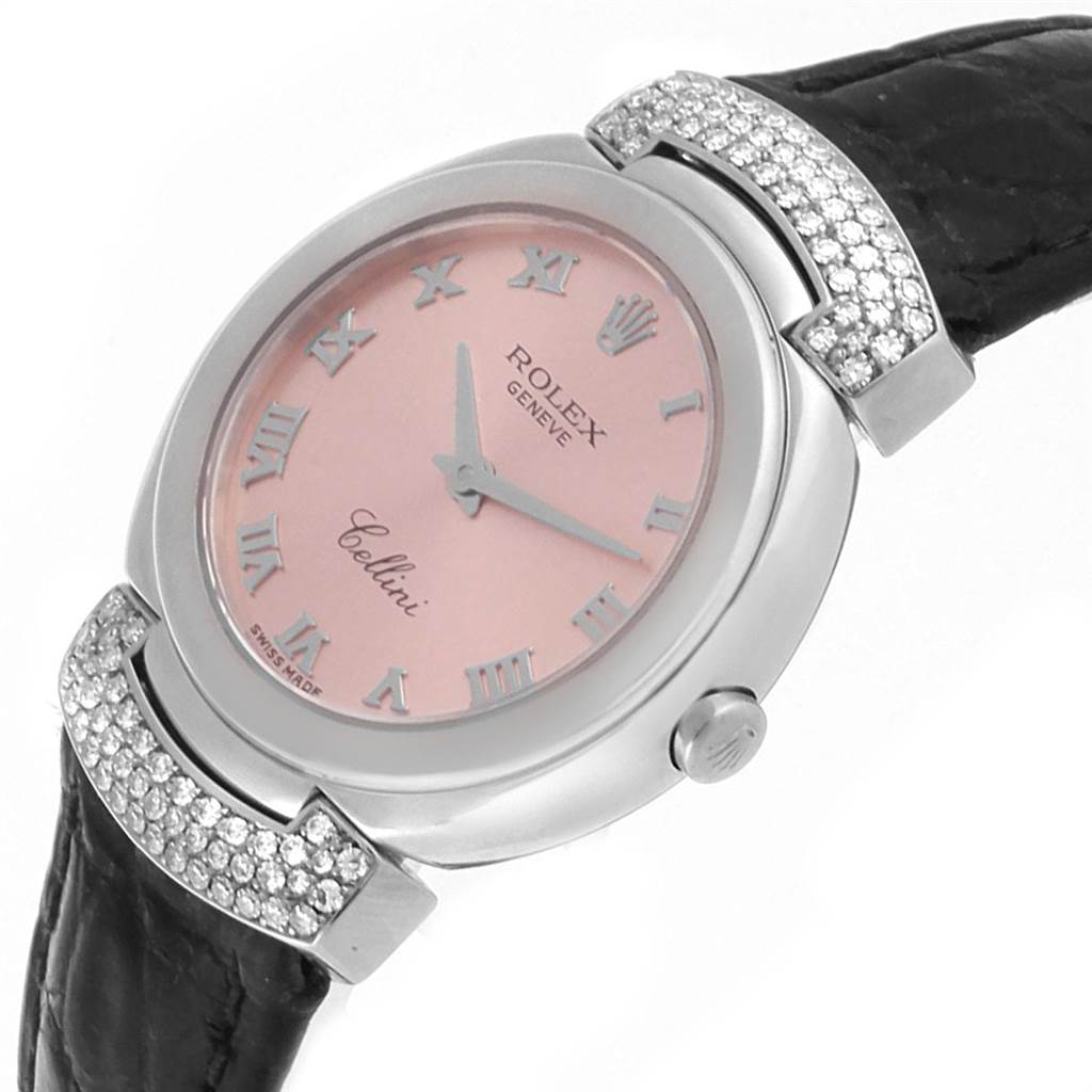 The Rolex Cellini 6672 Women's White Gold Pink Dial 6672 Women's White Gold Pink Dial watch is shown at an angled side view, revealing its pink face, roman numerals, and a portion of its leather strap with diamond accents.