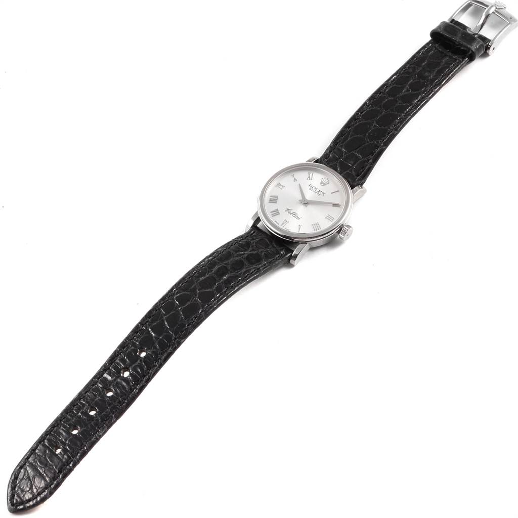 The image shows a full view of a Rolex Cellini 6110 Women
s White Gold Silver Dial 6110 Women
s White Gold Silver Dial watch with a black leather strap and a silver watch face, photographed from above.