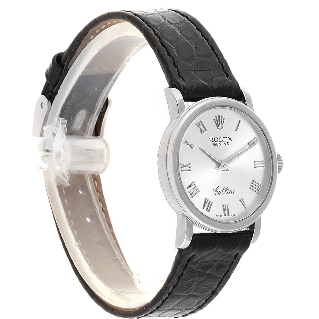 The Rolex Cellini 6110 Women
s White Gold Silver Dial 6110 Women
s White Gold Silver Dial watch is shown at an angled side view, displaying the watch face, case, and black leather strap.