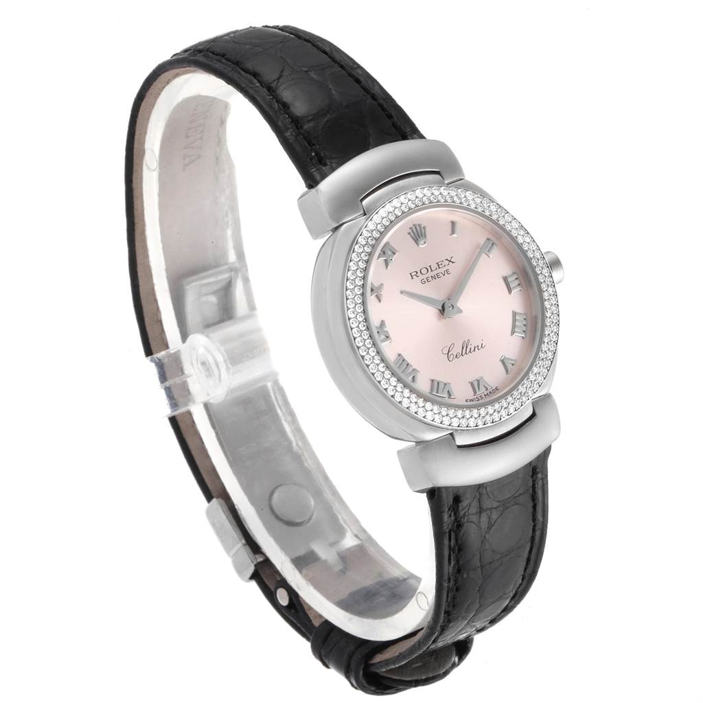The image shows a Rolex Cellini 6671 Women's White Gold Pink Dial 6671 Women's White Gold Pink Dial watch from a front-left angled view, highlighting its pink dial, diamond bezel, and black leather strap.