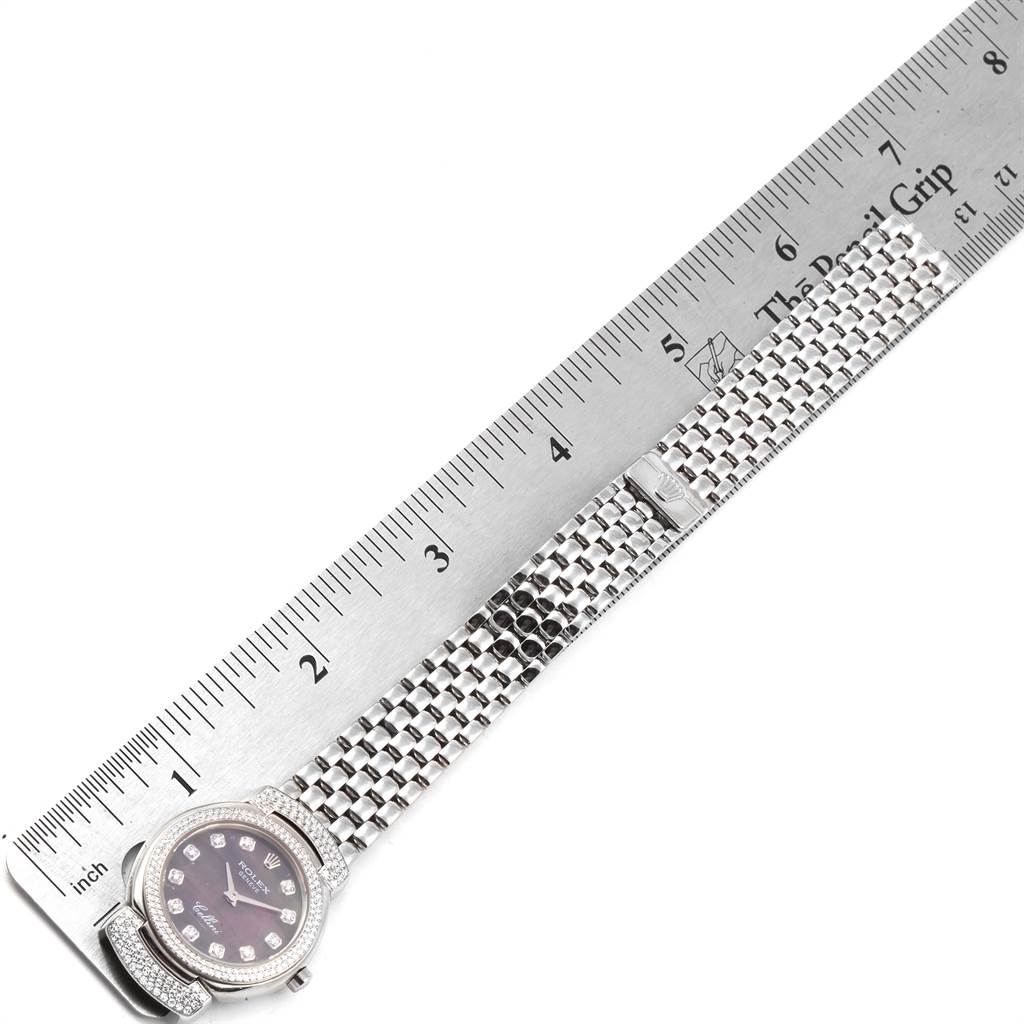 The Rolex Cellini 6673 Women's White Gold Mother of Pearl Dial 6673 Women's White Gold Mother of Pearl Dial watch is shown from a top-down angle, highlighting its face and band alongside a ruler for scale.