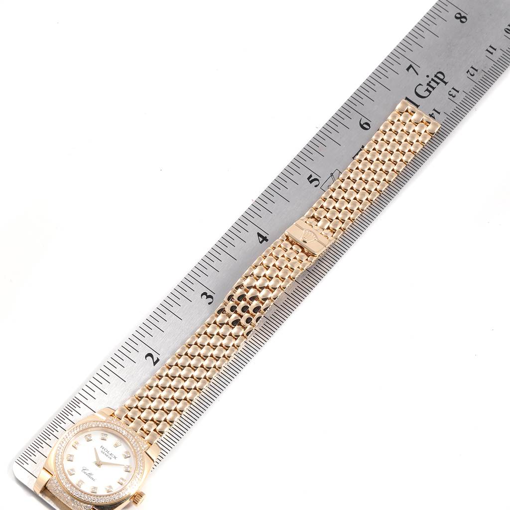 The image shows a Rolex Cellini 6311 Women's Yellow Gold White Dial 6311 Women's Yellow Gold White Dial watch laid flat next to a ruler, highlighting its face, bezel, and bracelet.